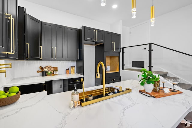 4758 S Ichabod St, Holladay, UT 84117 - kitchen with dark cabinetry, light stone countertops, and hanging light fixtures
