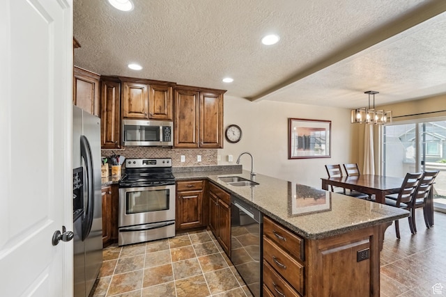 1069 N Independence Ave, Provo, UT 84604 - kitchen featuring appliances with stainless steel finishes, a sink, a peninsula, decorative backsplash, and a textured ceiling