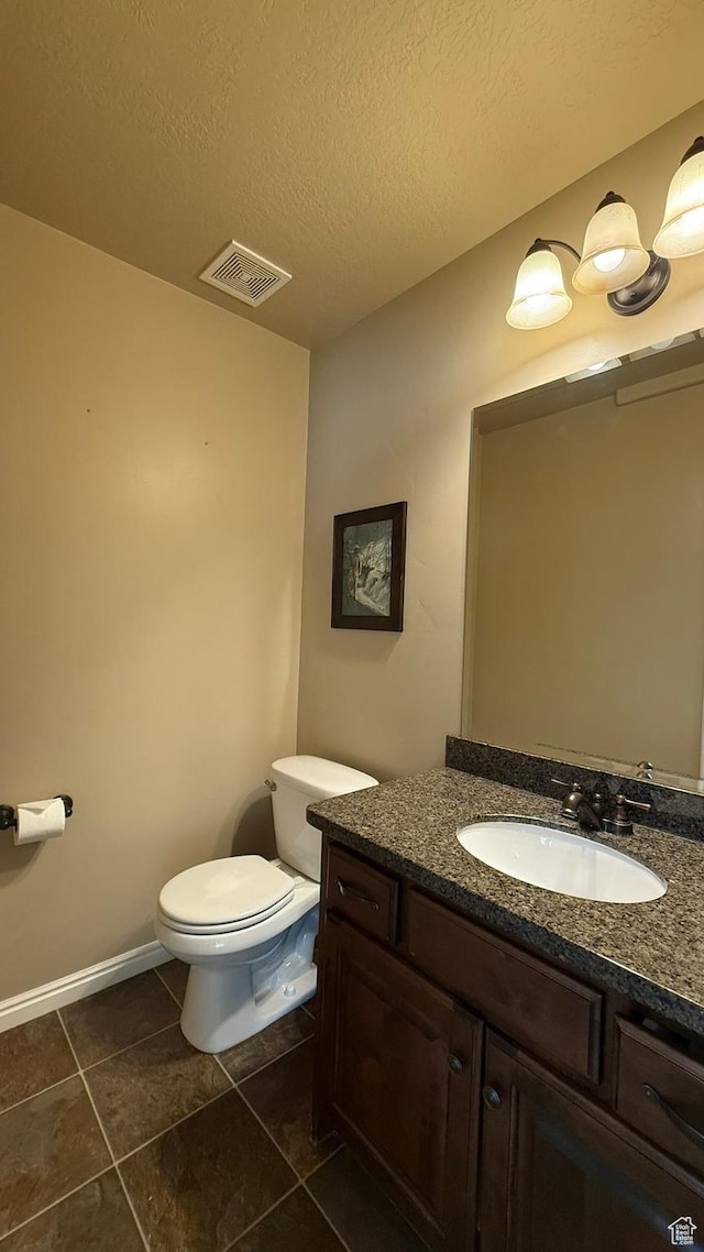 1069 N Independence Ave, Provo, UT 84604 - bathroom with tile patterned floors, toilet, vanity, a textured ceiling, and baseboards