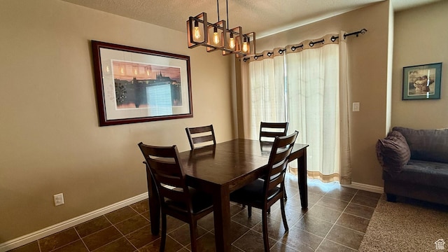 1069 N Independence Ave, Provo, UT 84604 - dining space with dark tile patterned flooring, a textured ceiling, a chandelier, and baseboards