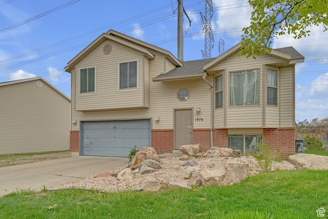 1976 N 1720 W, Clinton, UT 84015 - split foyer home with a garage, concrete driveway, and brick siding