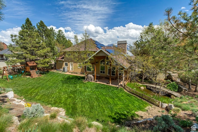 11362 Palisade View Dr, South Jordan, UT 84095 - rear view of property with a chimney, solar panels, a playground, a yard, and a patio
