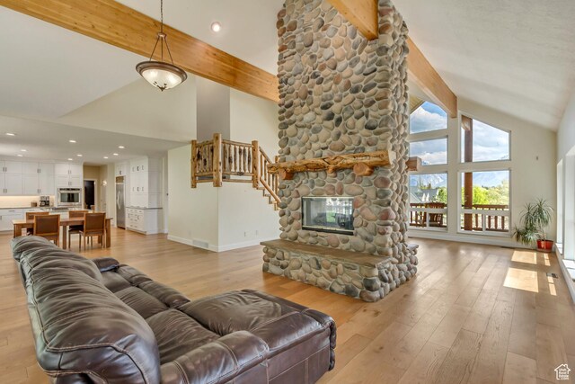 11362 Palisade View Dr, South Jordan, UT 84095 - living room featuring a stone fireplace, beam ceiling, high vaulted ceiling, baseboards, and light wood-style floors