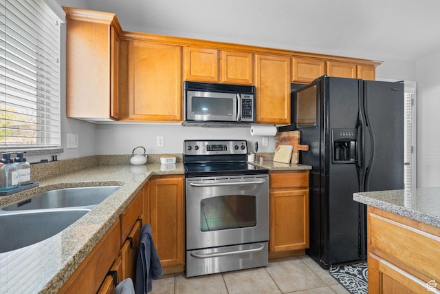 10751 S Pine Shadow Rd W, South Jordan, UT 84009 - kitchen featuring stainless steel appliances, light tile patterned floors, a sink, and brown cabinetry