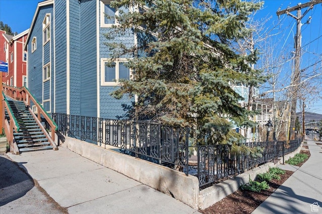 view of home's exterior with stairs and fence