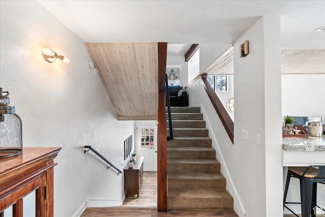 staircase featuring baseboards and wood finished floors