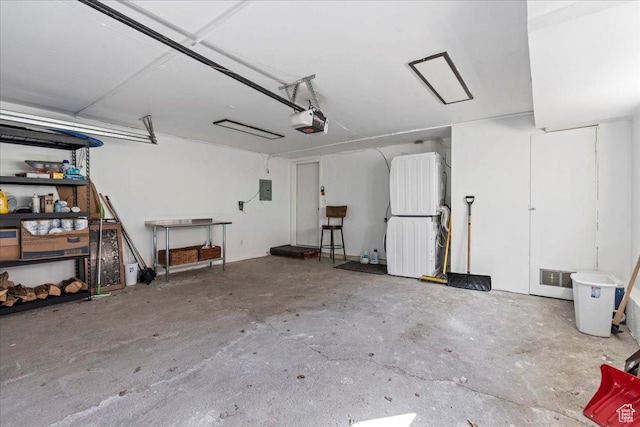 garage with visible vents, a garage door opener, and electric panel