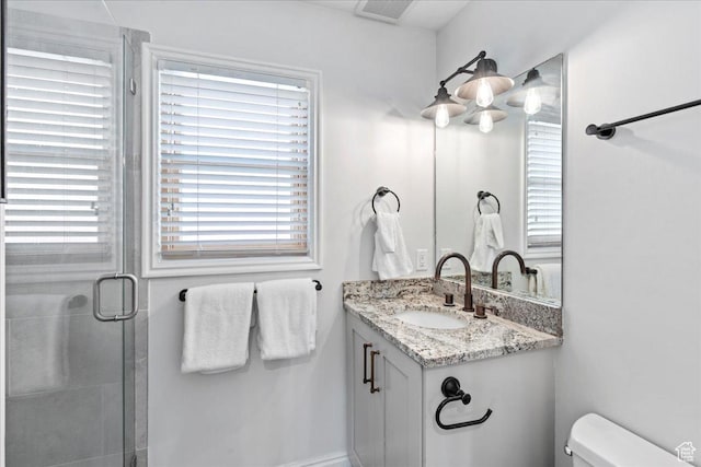 bathroom with an enclosed shower, toilet, visible vents, and vanity