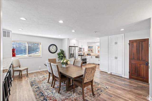 dining room featuring recessed lighting, baseboards, visible vents, and light wood-style flooring