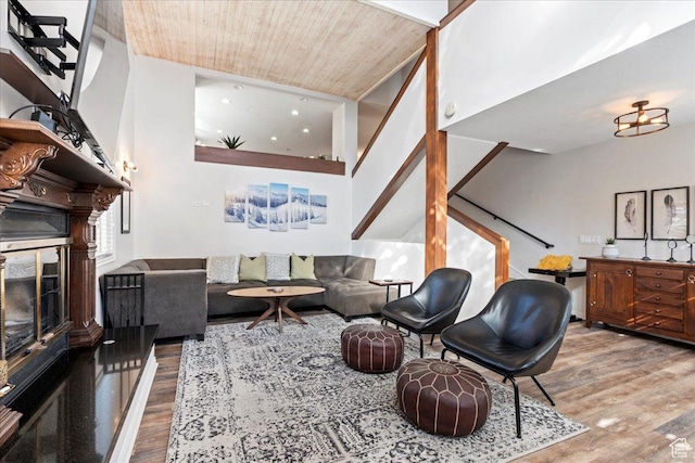 living area featuring wood ceiling, wood finished floors, stairway, and a fireplace