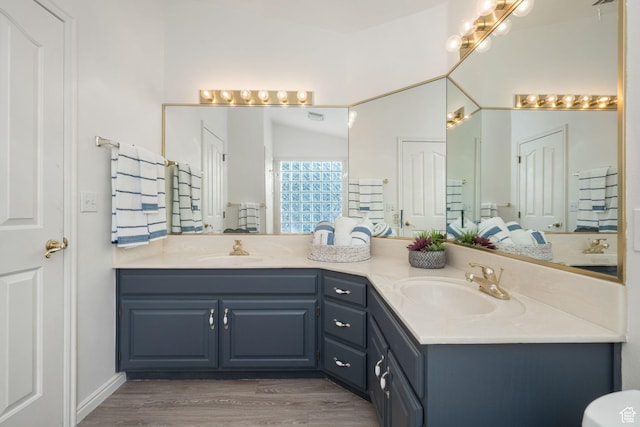 1864 S Crockett Cir, Bloomington, UT 84790 - bathroom with double vanity, vaulted ceiling, a sink, and wood finished floors