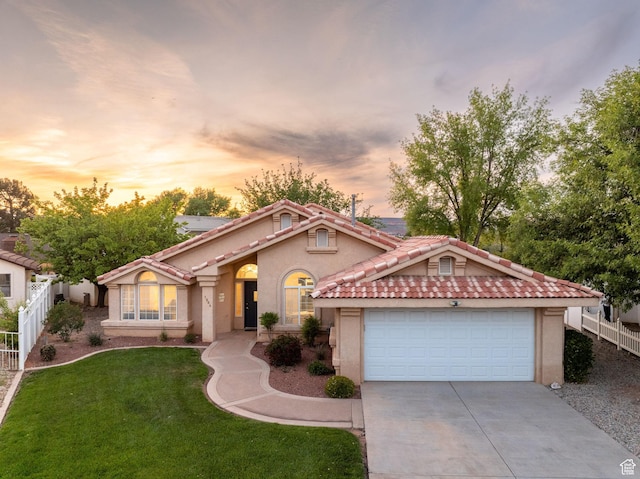 1864 S Crockett Cir, Bloomington, UT 84790 - mediterranean / spanish home with fence, stucco siding, concrete driveway, a tiled roof, and a yard