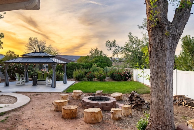 1864 S Crockett Cir, Bloomington, UT 84790 - yard at dusk featuring a gazebo, a fenced backyard, a patio area, and an outdoor fire pit