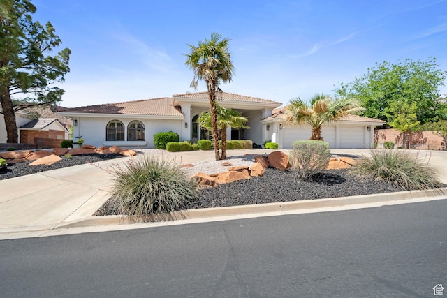 1026 Wesley Powell Dr, St George, UT 84790 - view of front of property featuring concrete driveway, a tiled roof, stucco siding, and a garage