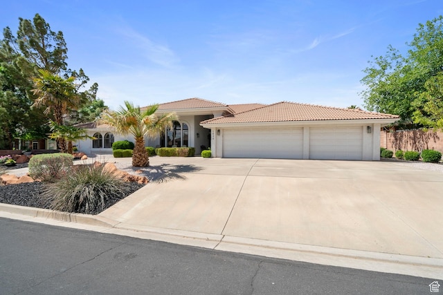 1026 Wesley Powell Dr, St George, UT 84790 - view of front facade featuring a garage, stucco siding, a tiled roof, and concrete driveway