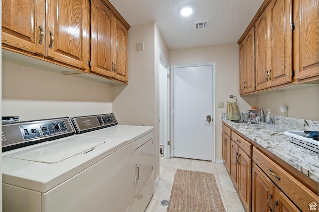 1026 Wesley Powell Dr, St George, UT 84790 - laundry area featuring visible vents, washing machine and dryer, cabinet space, a sink, and light tile patterned floors