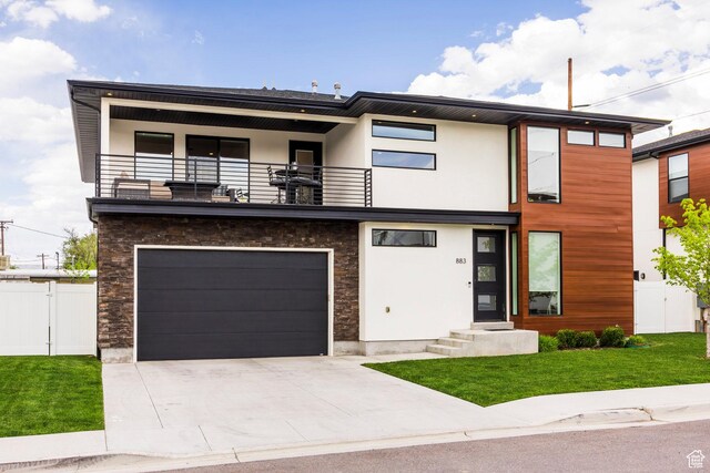 883 E Sydnee View Ln, Millcreek, UT 84107 - modern home featuring fence, an attached garage, a front lawn, a balcony, and driveway