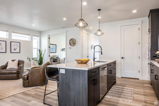 883 E Sydnee View Ln, Millcreek, UT 84107 - kitchen featuring appliances with stainless steel finishes, a sink, light countertops, an island with sink, and light wood-style flooring
