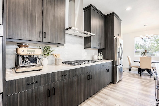 883 E Sydnee View Ln, Millcreek, UT 84107 - kitchen featuring light countertops, wall chimney exhaust hood, a chandelier, appliances with stainless steel finishes, and backsplash