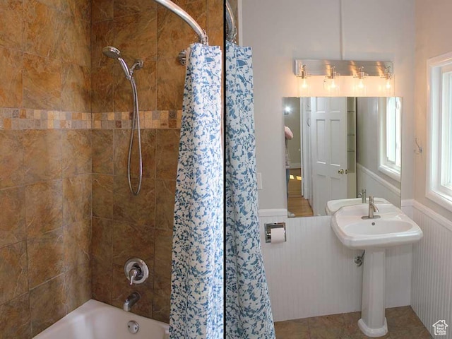 full bathroom with shower / bath combo with shower curtain and a wainscoted wall