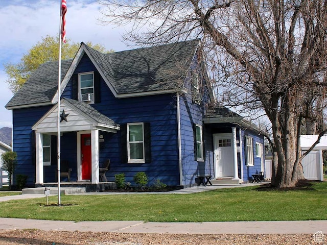 view of front of property with a shingled roof and a front yard