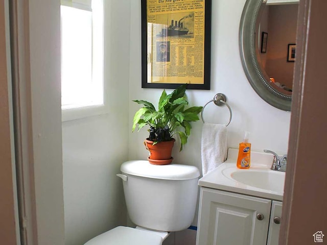 half bath featuring vanity and toilet