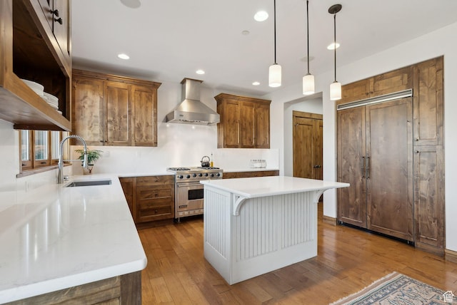 3250 E Thunderhawk Trl, Heber City, UT 84036 - kitchen featuring a sink, wall chimney exhaust hood, brown cabinets, and premium stove