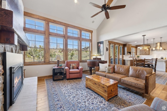 3250 E Thunderhawk Trl, Heber City, UT 84036 - living room with light wood-type flooring, a ceiling fan, a glass covered fireplace, and high vaulted ceiling