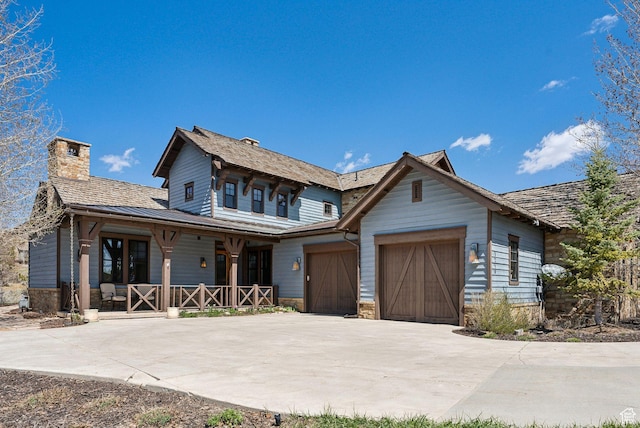 3250 E Thunderhawk Trl, Heber City, UT 84036 - view of front of home featuring covered porch, an attached garage, concrete driveway, and a chimney