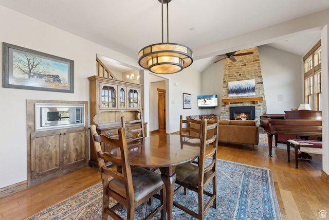 3250 E Thunderhawk Trl, Heber City, UT 84036 - dining room featuring ceiling fan, vaulted ceiling, light wood finished floors, and a stone fireplace