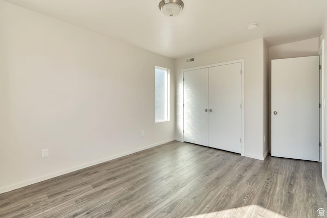 11611 S Alexandria W, South Jordan, UT 84009 - unfurnished bedroom with a closet, baseboards, wood finished floors, and visible vents