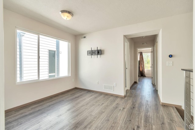 11611 S Alexandria W, South Jordan, UT 84009 - unfurnished room with baseboards, a textured ceiling, wood finished floors, and visible vents