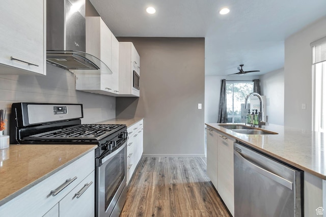11611 S Alexandria W, South Jordan, UT 84009 - kitchen with appliances with stainless steel finishes, a sink, wall chimney exhaust hood, white cabinetry, and wood finished floors