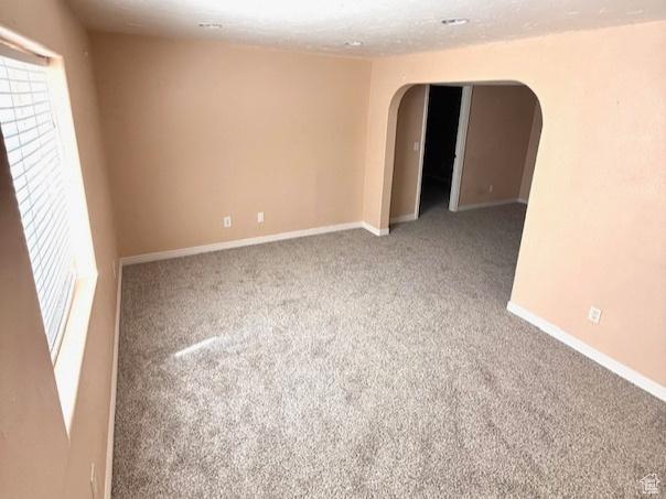863 S 1520 E, Spanish Fork, UT 84660 - carpeted empty room featuring plenty of natural light, arched walkways, and baseboards