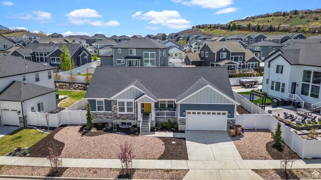 2438 E Lone Hill Dr, Draper, UT 84020 - view of front of house featuring board and batten siding, concrete driveway, a residential view, and stone siding