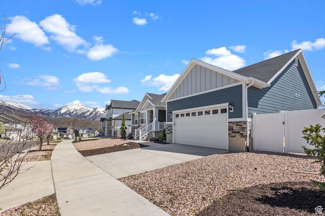 2438 E Lone Hill Dr, Draper, UT 84020 - view of front of house featuring a garage, fence, stone siding, board and batten siding, and driveway