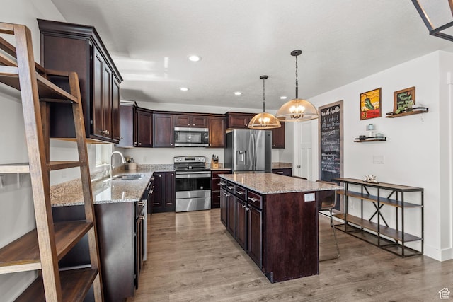 2438 E Lone Hill Dr, Draper, UT 84020 - kitchen featuring dark brown cabinets, a kitchen breakfast bar, a sink, light wood finished floors, and stainless steel appliances