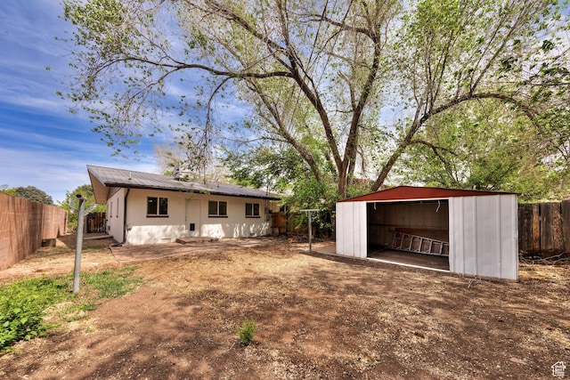 127 Birch Ave, Moab, UT 84532 - back of property featuring a fenced backyard, an outbuilding, and metal roof