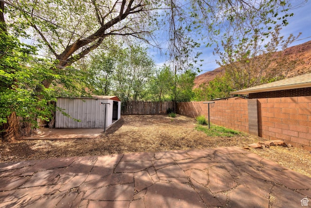 127 Birch Ave, Moab, UT 84532 - view of patio with an outbuilding, a fenced backyard, and a storage unit