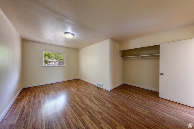127 Birch Ave, Moab, UT 84532 - unfurnished bedroom featuring a textured ceiling, baseboards, wood finished floors, visible vents, and a closet
