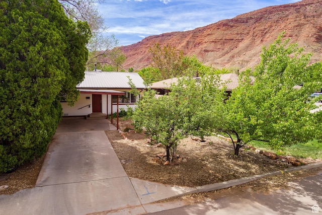 127 Birch Ave, Moab, UT 84532 - view of front of property featuring a carport, a mountain view, metal roof, and concrete driveway