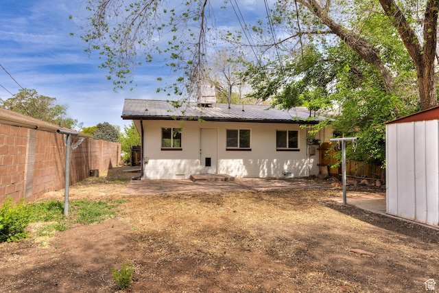 127 Birch Ave, Moab, UT 84532 - rear view of property with a fenced backyard, concrete block siding, a patio, and metal roof