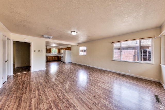 127 Birch Ave, Moab, UT 84532 - unfurnished living room with dark wood finished floors and a textured ceiling