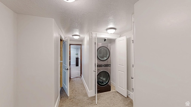 997 W 675 S, Mapleton, UT 84664 - clothes washing area featuring stacked washer and clothes dryer, light colored carpet, a textured ceiling, and baseboards