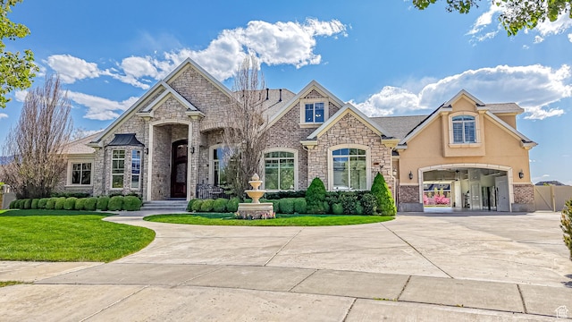 997 W 675 S, Mapleton, UT 84664 - french country inspired facade featuring stone siding, curved driveway, a front lawn, and an attached garage