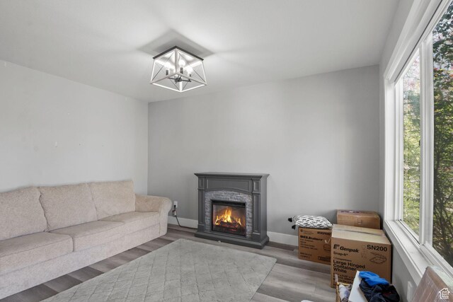1635 W 700 S, Lehi, UT 84043 - living area featuring a glass covered fireplace, baseboards, wood finished floors, and a notable chandelier
