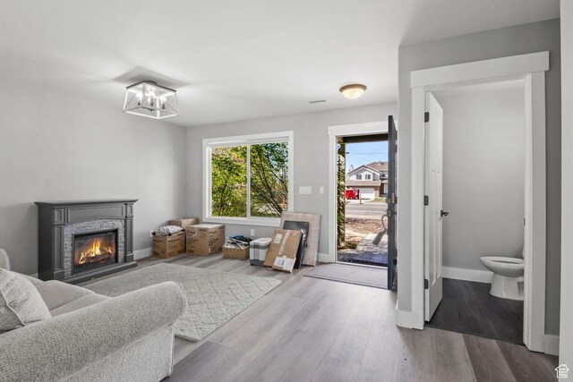 1635 W 700 S, Lehi, UT 84043 - living area featuring a notable chandelier, baseboards, a glass covered fireplace, and wood finished floors