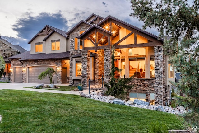 craftsman house with an attached garage, a front lawn, stone siding, and concrete driveway