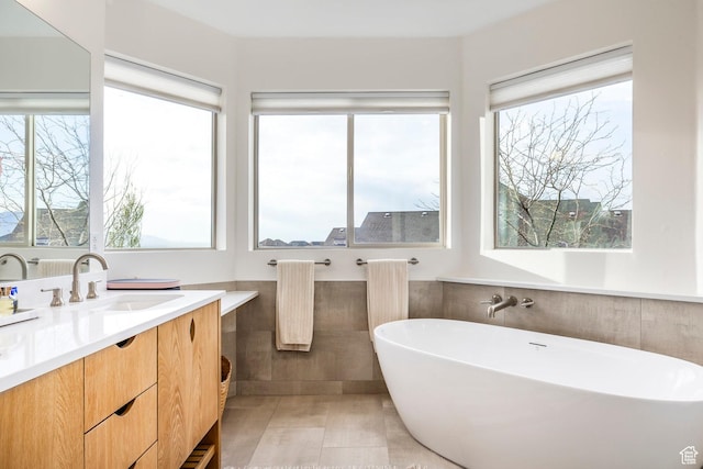 1263 E Wild Maple Ct, Draper, UT 84020 - bathroom featuring vanity, tile walls, a wealth of natural light, and a soaking tub