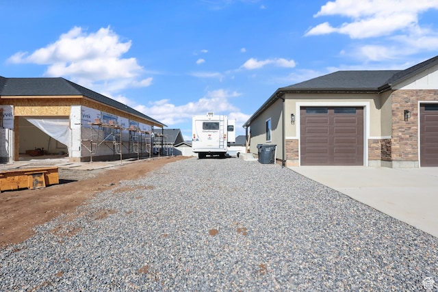1167 N 150 E Unit 53, Nephi, UT 84648 - view of property exterior featuring stucco siding, driveway, stone siding, and a garage